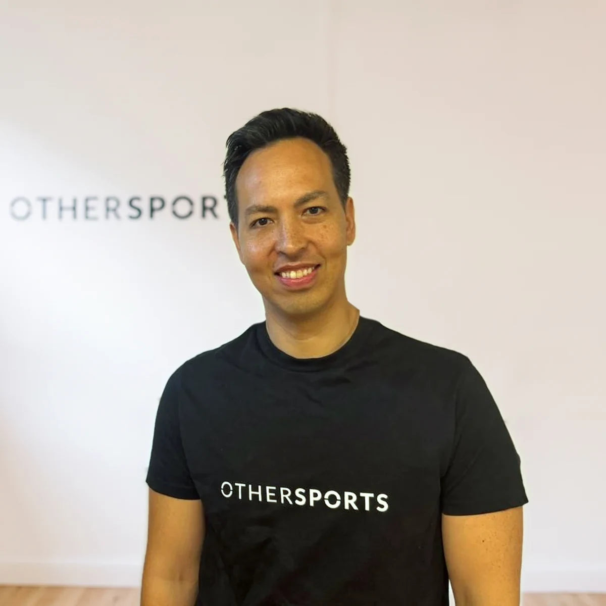 Ronny Herrmann im Trainingsraum, im Hintergrund das OTHERSPORTS-Schild