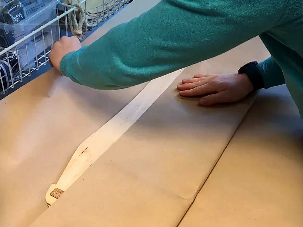 Ein Board wird von Hand in Packpapier eingeschlagen